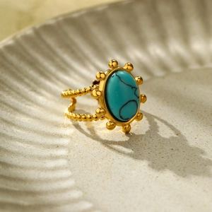 Detailopname van een vintage gouden ring met kralenrand en ovale turquoise steen
