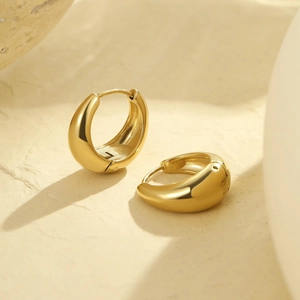 Detailed view of chunky 18k gold plated hoop earrings with mirror finish on stone base