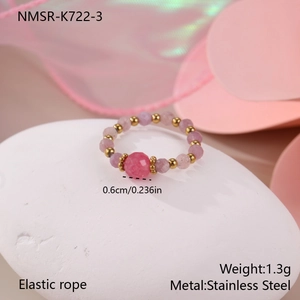 Detailed macro view of pink beaded elastic ring with gold stainless steel spacers