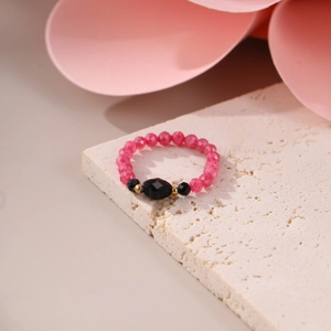 Close-up of beaded stone ring with pink and black faceted gems and 18K gold spacers