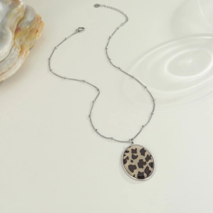 Dettaglio della collana con ciondolo ovale leopardato e catena argentata perlata