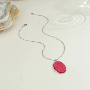 Dettaglio macro della catena a sfere d'argento con pendente in resina rosa marmorizzata