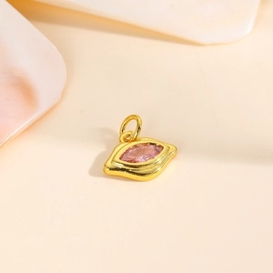 Macro shot of 18k gold plated eye-shaped pendant with pink marquise zircon
