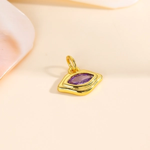 Macro detail of eye-shaped 18k gold plated pendant with purple marquise zircon stone