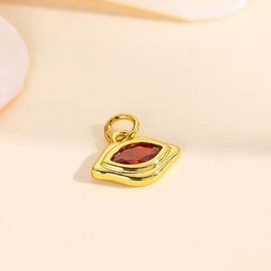 Close-up of eye-shaped gold pendant with red marquise zirconia for jewelry DIY