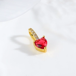Macro shot of a red heart pendant with 18k gold plating and white zircon bail
