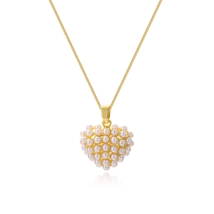 Detailed view of heart-shaped gold necklace pendant set with white round pearls