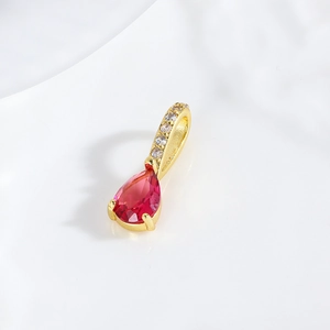 Macro view of 18k gold plated teardrop pendant with a faceted red zircon gemstone