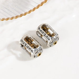 Macro view of Tibetan prayer wheel spacer beads with engraved lotus and mantra motifs