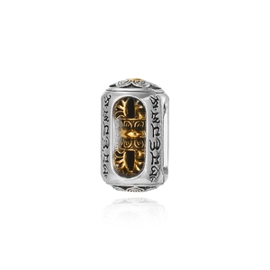 Ethnic style silver and gold cylinder bead featuring hollow vajra and Tibetan symbols