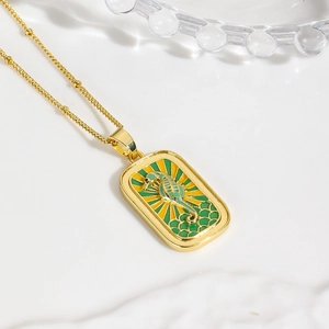 Close-up of a gold seahorse tarot pendant with colorful enamel on a delicate cross chain
