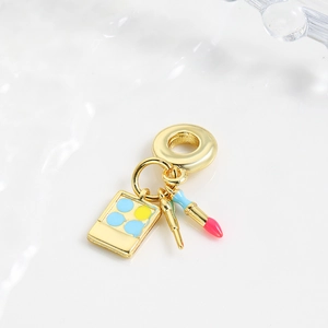 Detailed macro view of cosmetics charms with lipstick, eyeshadow, and brush for DIY bracelets