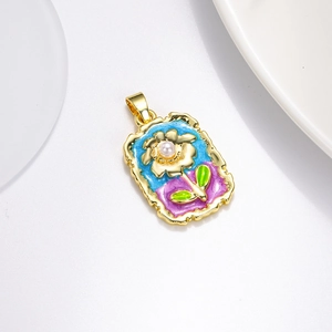 Vue détaillée du pendentif fleuri avec émail bleu, plaquage or et perle d'imitation