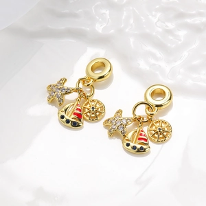 Detailed view of ocean-themed charms with starfish, sailboat and rudder in gold plating