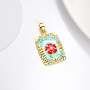 Détail macro du pendentif rectangulaire en émail bleu clair avec fleur rouge et perle