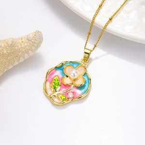 Détail du collier pendentif rose en émail avec centre en perle et chaîne dorée sur fond blanc