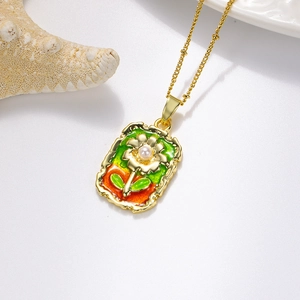 Détail du pendentif rose vintage avec émail vert et perle sur une fine chaîne dorée