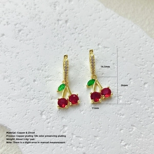 Detalle de pendientes de cereza con circonitas rojas y hojas de circón verde