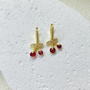Vista de detalle de pendientes de cereza con cristales rojos y hojas de micro pavé
