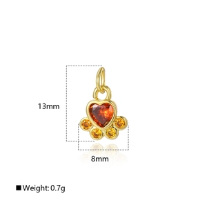 Detail of 13x8mm 18k gold heart dog paw pendant with micro-set orange gemstones
