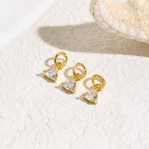 Macro detail of triangle zircon pendants in gold plating for DIY jewelry making