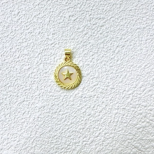 Detalle de un colgante de estrella en oro de 18K con incrustación de concha y borde