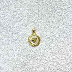 Detalle de colgante de corazón con borde dorado trenzado e incrustación de nácar