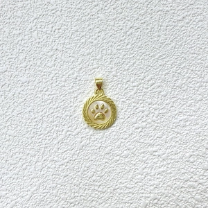Detalle macro del colgante de huella dorada con incrustación de nácar blanco para DIY