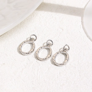 Detailed view of silver oval hammer-textured metal pendants for DIY jewelry crafting