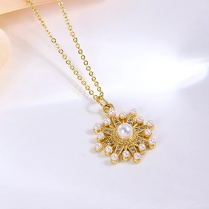 Nahaufnahme des goldenen Sonnenblumenanhängers mit Perle und strahlenden Perlen