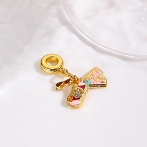 Macro view of gold-plated travel charms set featuring camera, sunglasses and boarding passes