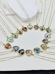 Macro detail of heart-shaped religious pendants with gold plating and CZ crystal inlay
