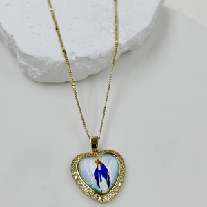 Macro detail of heart-shaped Virgin Mary pendant with gold finish and zircon pave