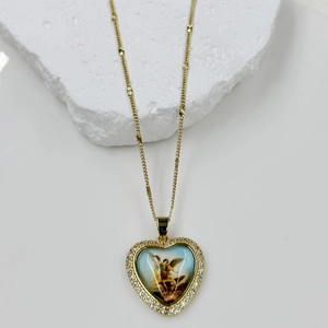 Detail of gold heart pendant with blue religious icon and micro-paved white zircons