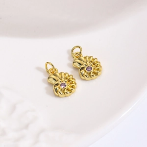 Detailopname van gouden spiraalschelpbedeltjes met paarse zirkoon voor DIY-sieraden
