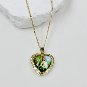 Detailed close-up of a gold heart pendant with zircon inlay and St. Jude religious icon