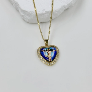 Close-up of golden heart pendant with religious icon and sparkling zircon border