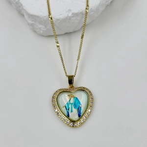 Close-up of heart-shaped gold necklace pendant with Virgin Mary icon and zircon inlay
