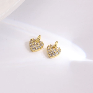 Macro shot of gold-plated heart charms with micro-paved cubic zirconia for DIY jewelry