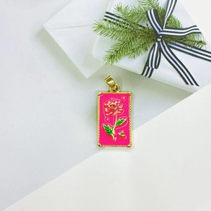 Detailed macro view of pink enamel rose mushroom tarot pendant with golden metal edges