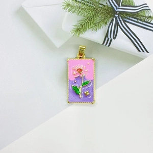 Macro shot of rectangular enamel rose flower pendant with gold plated metal finish