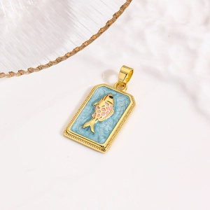 Macro detail van een gouden vis hanger met blauw emaille op een witte steen achtergrond