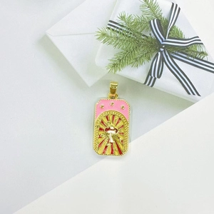 Detailed view of tarot style gold necklace pendant with rose and mushroom on a gift box