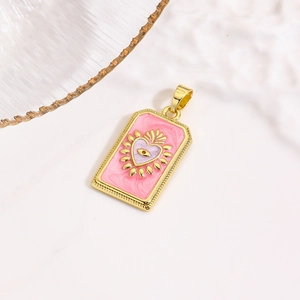 Detail van een rechthoekige gouden hanger met roze emaille en evil eye hartontwerp