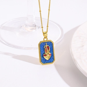 Detail van gouden kralenketting en blauwe emaille hart hanger op witte achtergrond