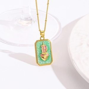Macro-opname van een vierkante gouden ketting met groen emaille heilig hart