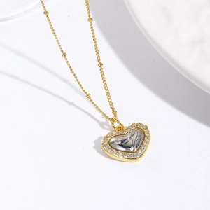 Detail der 18k Gold Herz-Halskette mit Zirkonia-Pavé und silberner Relief-Prägung