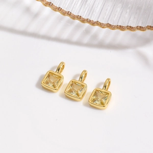 Detailed view of three 18k gold plated square pendants with yellow zircon gemstones