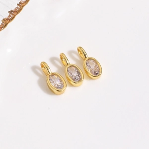 Detailed view of three gold-plated oval zircon pendants for DIY jewelry making