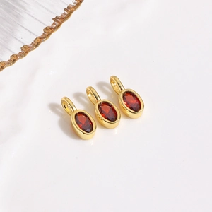Macro shot of oval red zircon pendant with gold bezel for DIY jewelry making charms